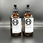Faire Taire hair care duo on a black background, with shampoo and conditioner bottles side by side.
