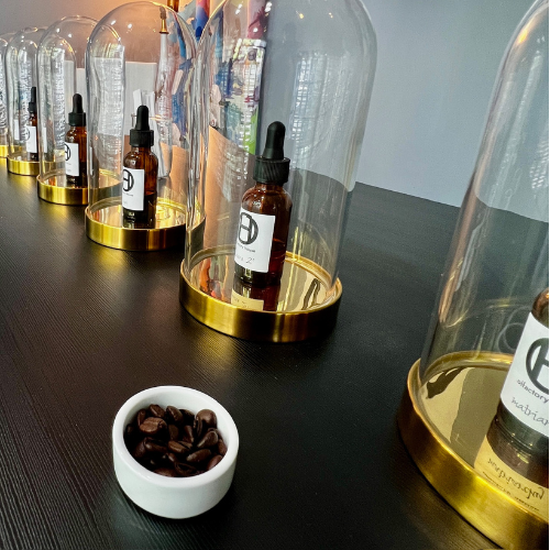 The perfume bar at Olfactory House has scents under glass cloches. Coffe beans sit nearby to cleanse the scent.